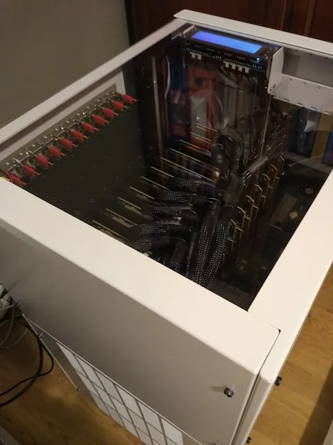 The 2017 world-first 11-GPU prototype — eleven red PCIe latches in a row under the glass top, original build documentation